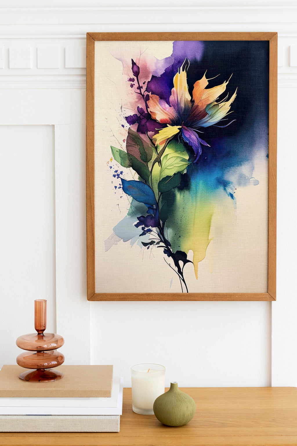 a framed painting of a colorful flower on a wall, with a wooden shelf below it holding a stack of books, a small green vase, and a white candle.