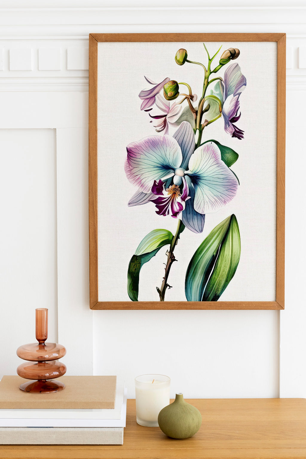 a framed botanical illustration of a purple orchid plant hanging on a wall above a wooden table with various decorative items, including a candle, a small green vase, and a stack of books.