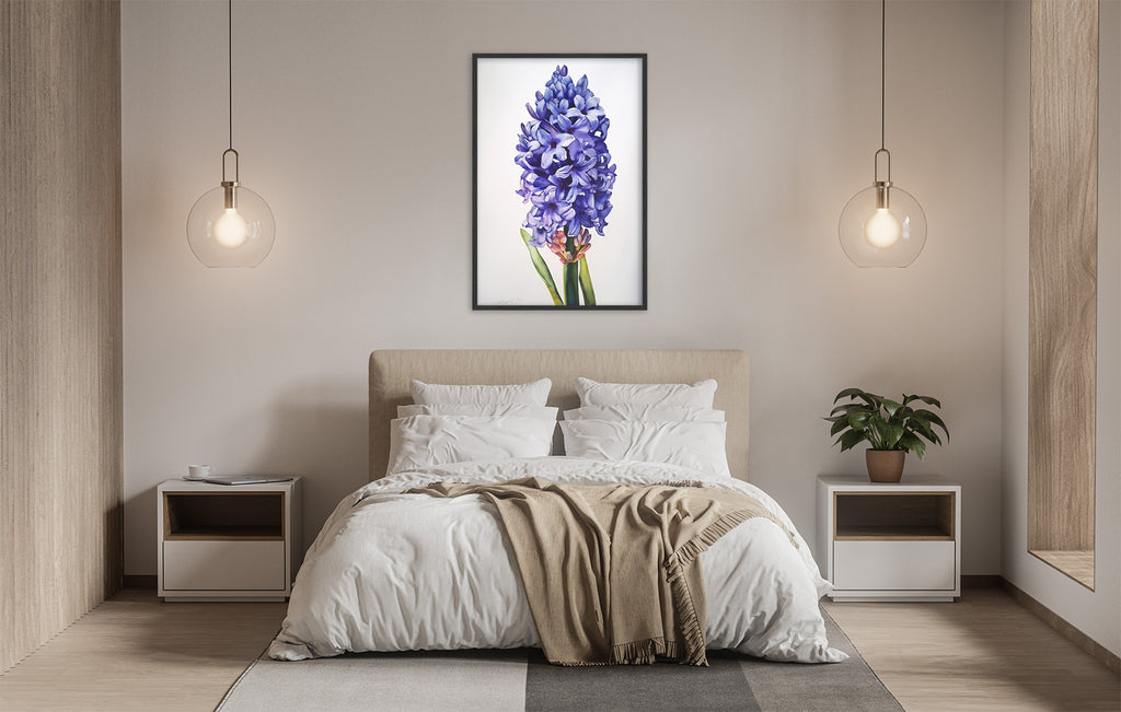 a serene and modern bedroom with a large bed, white bedding, and a framed picture of a purple hyacinth flower hanging above it. The room is illuminated by two pendant lights, creating a warm and inviting atmosphere.