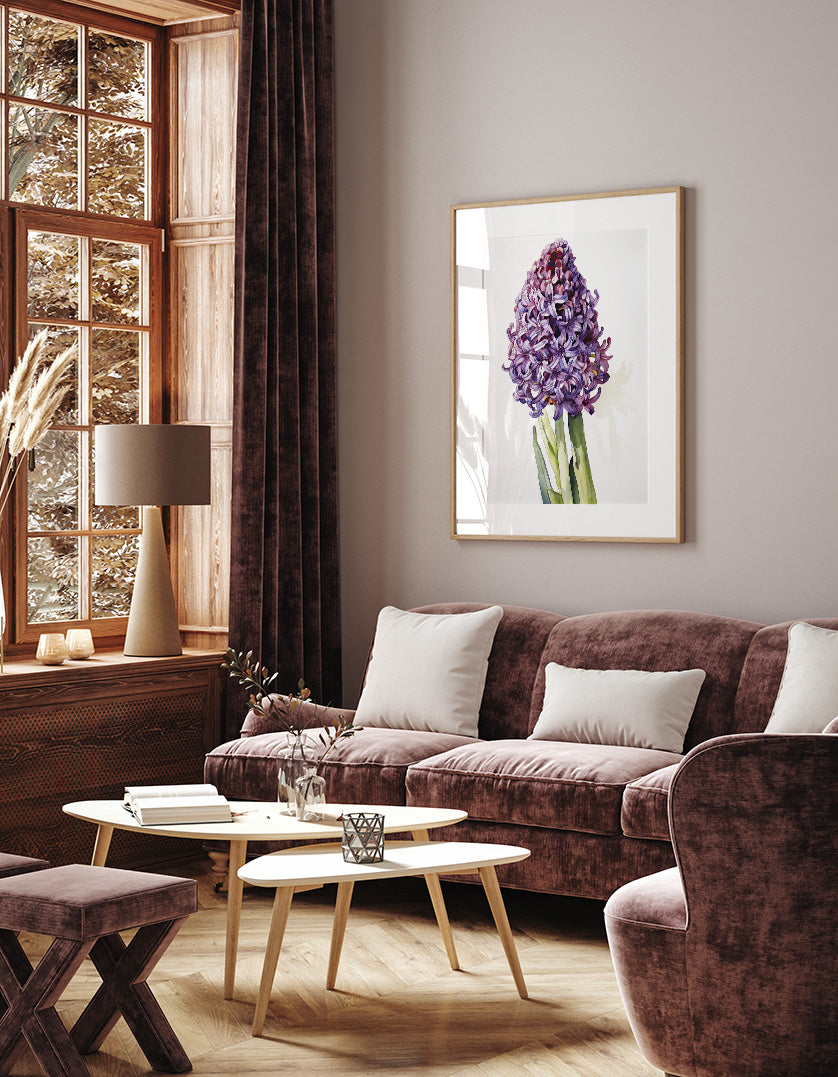 a cozy living room with a large window, a brown sofa, a wooden coffee table, and a framed picture of a purple flower on the wall.