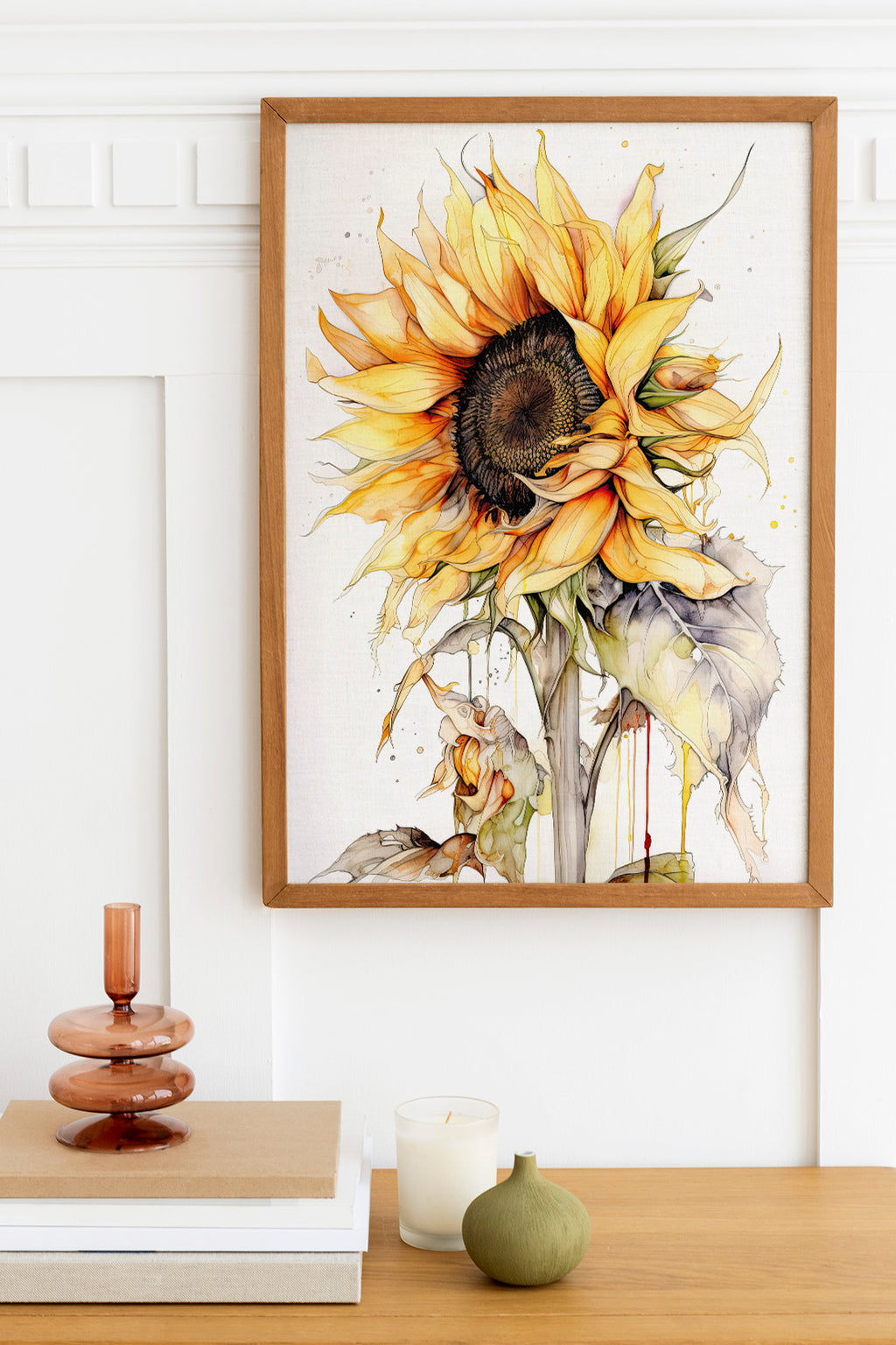 a framed painting of a vibrant sunflower on a wall, with a wooden shelf below it holding a stack of books, a small green vase, and a white candle.