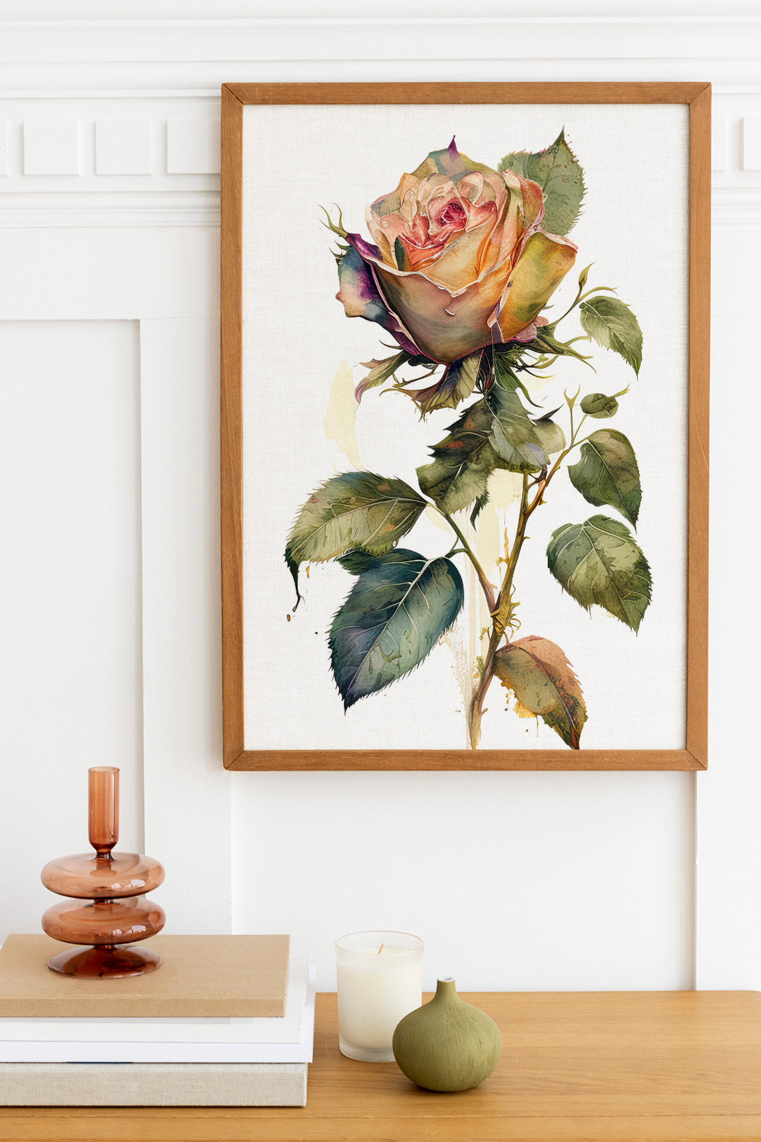 a framed painting of a vibrant rose with lush green leaves, displayed on a wall above a wooden table with various decorative items.