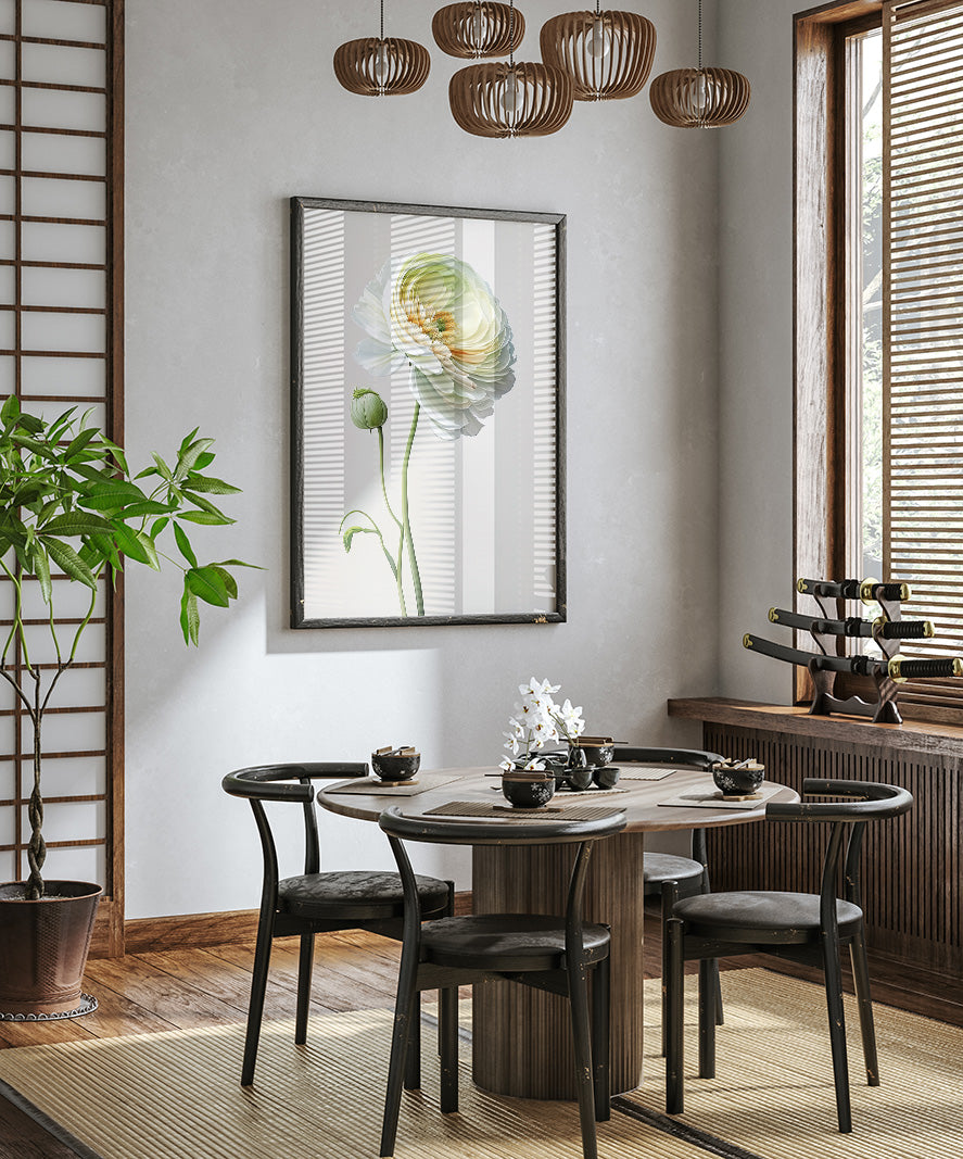 a modern dining room with a round wooden table, black chairs, and a large potted plant. A framed picture of a flower hangs on the wall above the table, and a chandelier hangs from the ceiling. The room has a minimalist and elegant design, with a wooden floor and a large window providing natural light.