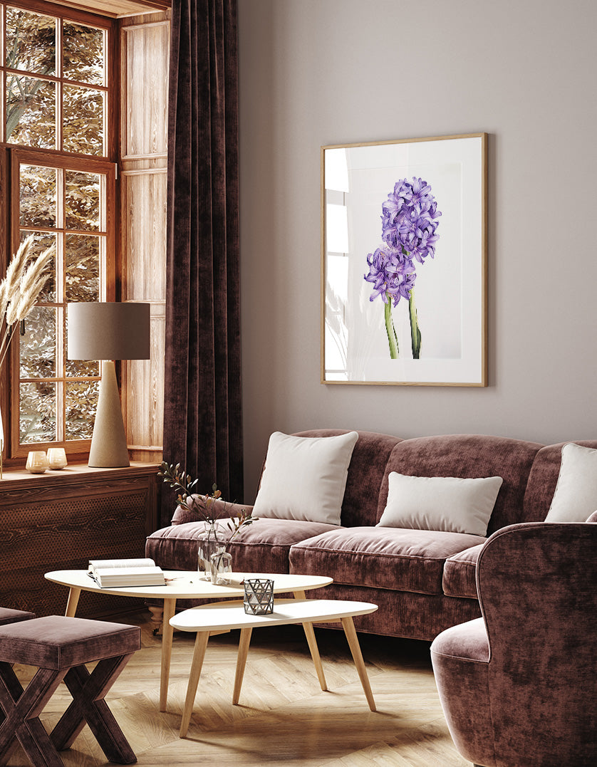 a cozy living room with a large window, a brown sofa, a wooden coffee table, and a framed picture of purple flowers on the wall.