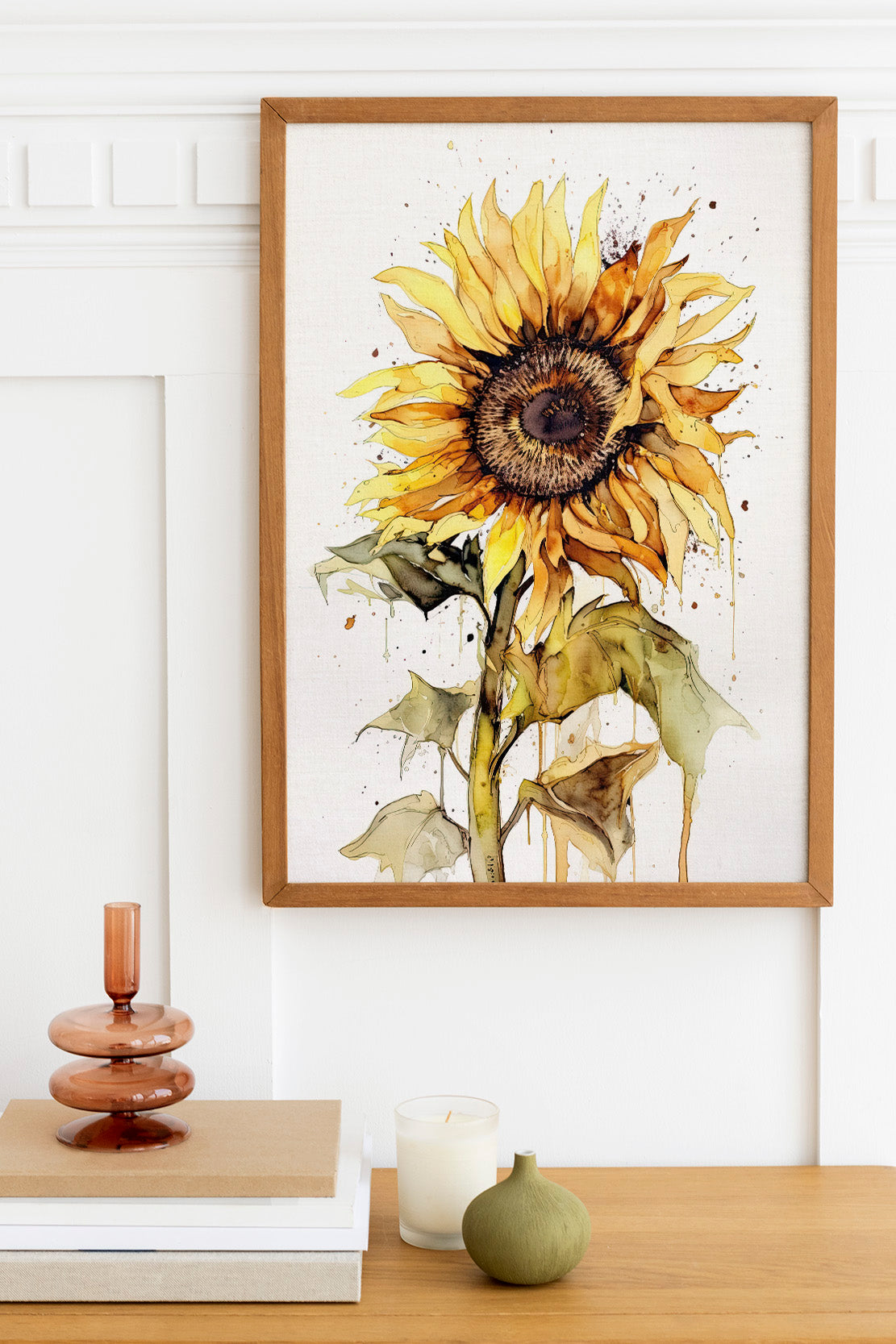 a framed watercolor painting of a sunflower hanging on a wall above a wooden table with various decorative items on it.