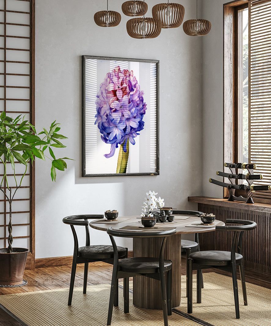 a modern dining room with a round wooden table, four black chairs, and a large framed picture of a purple flower hanging on the wall above the table.